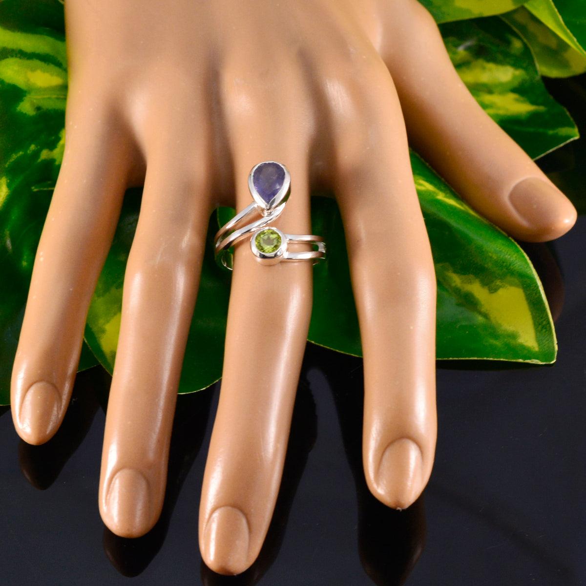 Ida toi et moi gemstone ring silver bypass band with pear purple and round green stones on mannequin hand