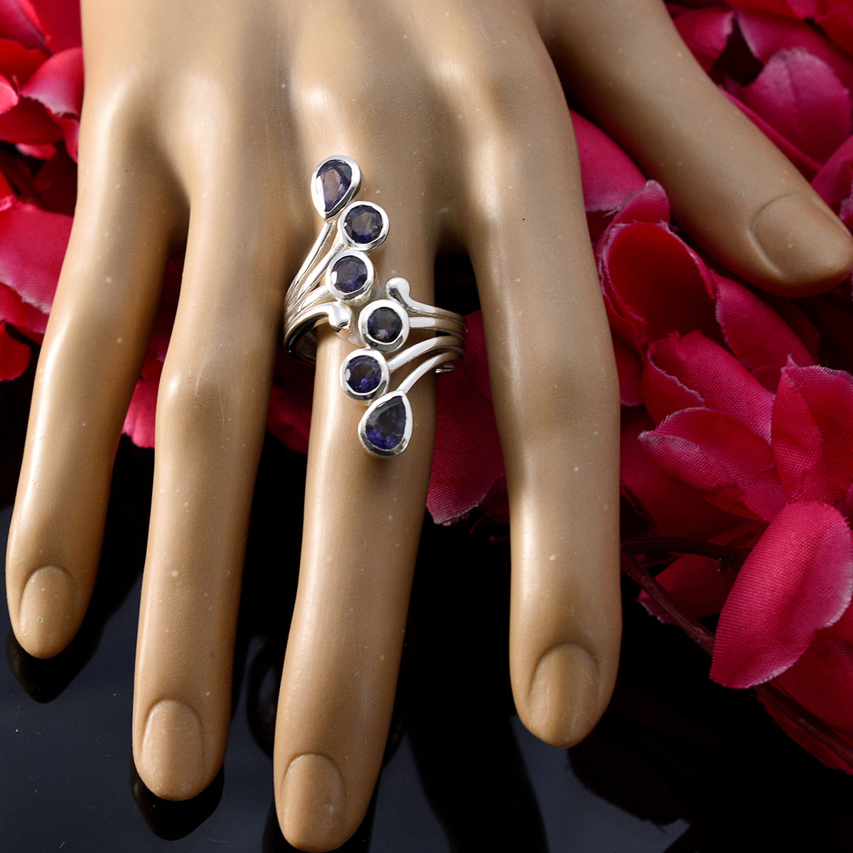 Yasmine modern blue gemstone ring with multiple oval blue stones on silver band displayed on hand