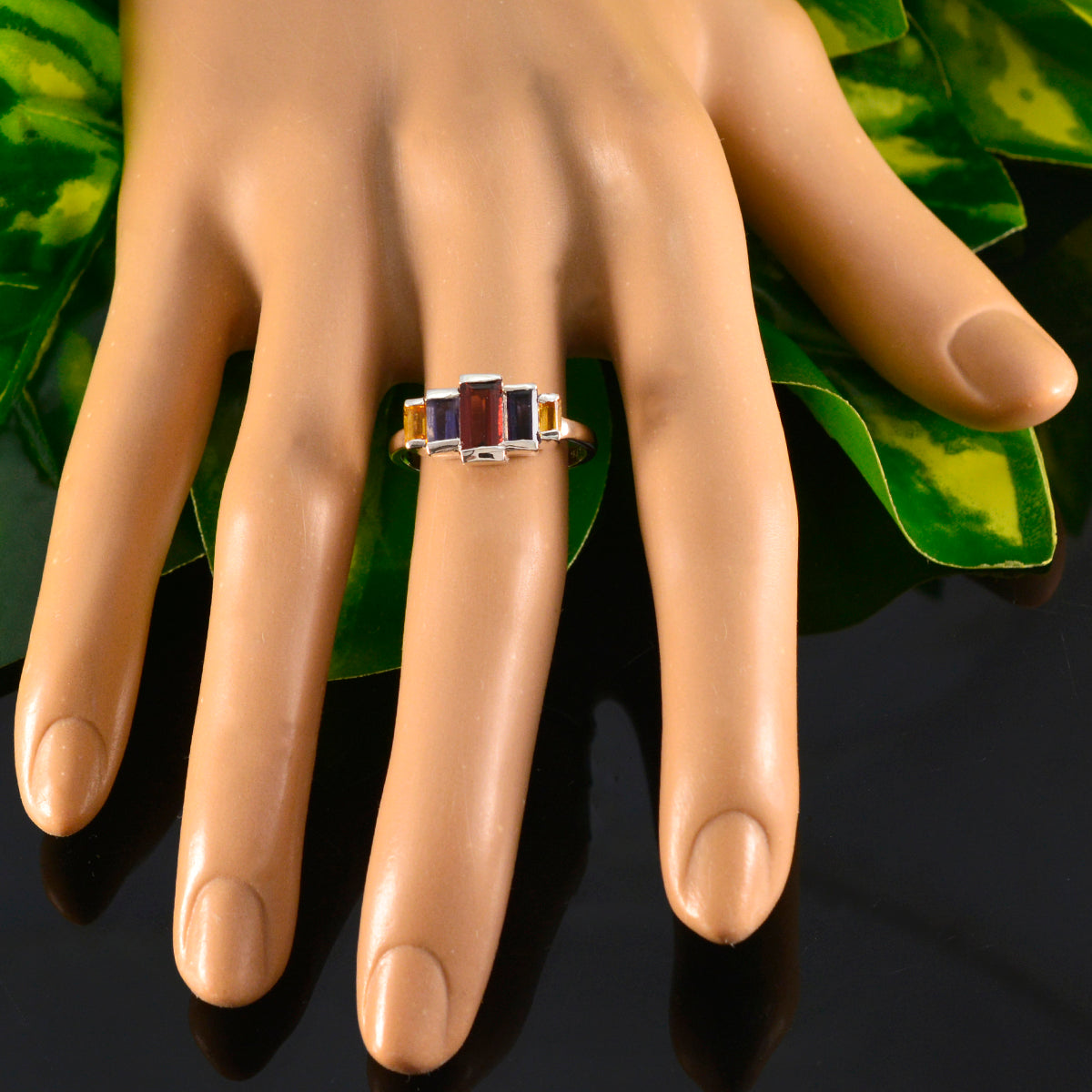 Rina multicolor gemstone ring for women displayed on a mannequin hand with rectangular red and amber stones