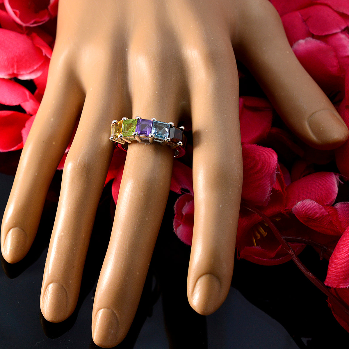 Katharina multicolor gemstone ring with rectangular stones on a hand display against pink petals background
