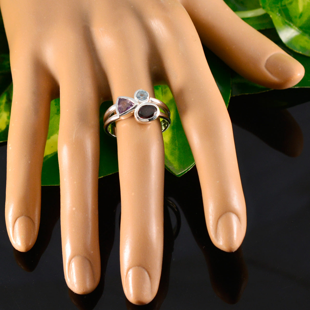 Siti multicolor gemstone trilogy ring with three distinct stones on a silver band displayed on a hand model