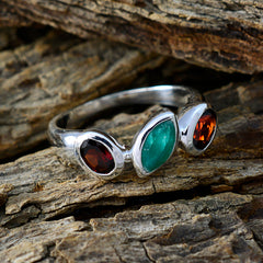 Patricia multicolor gemstone trilogy ring with green and red stones set in silver band on wood background