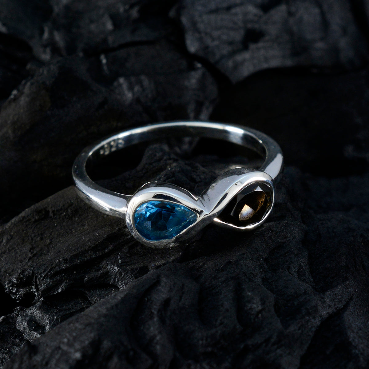 Victoria silver multicolor toi et moi ring with blue and brown gemstones on black textured background