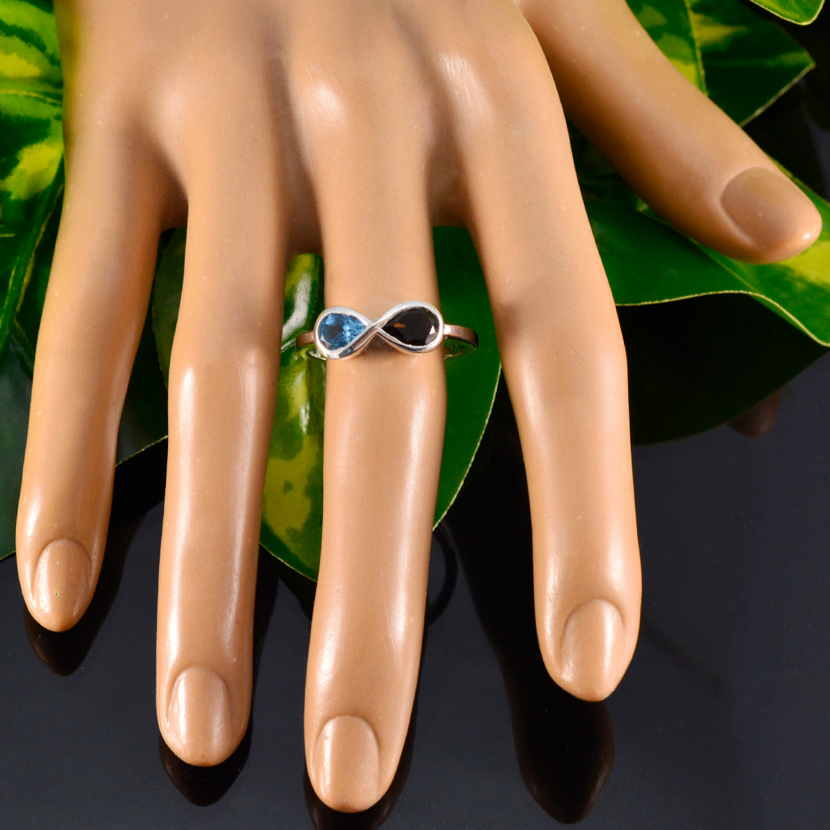 Victoria multicolor toi et moi ring with blue and black stones on a display hand
