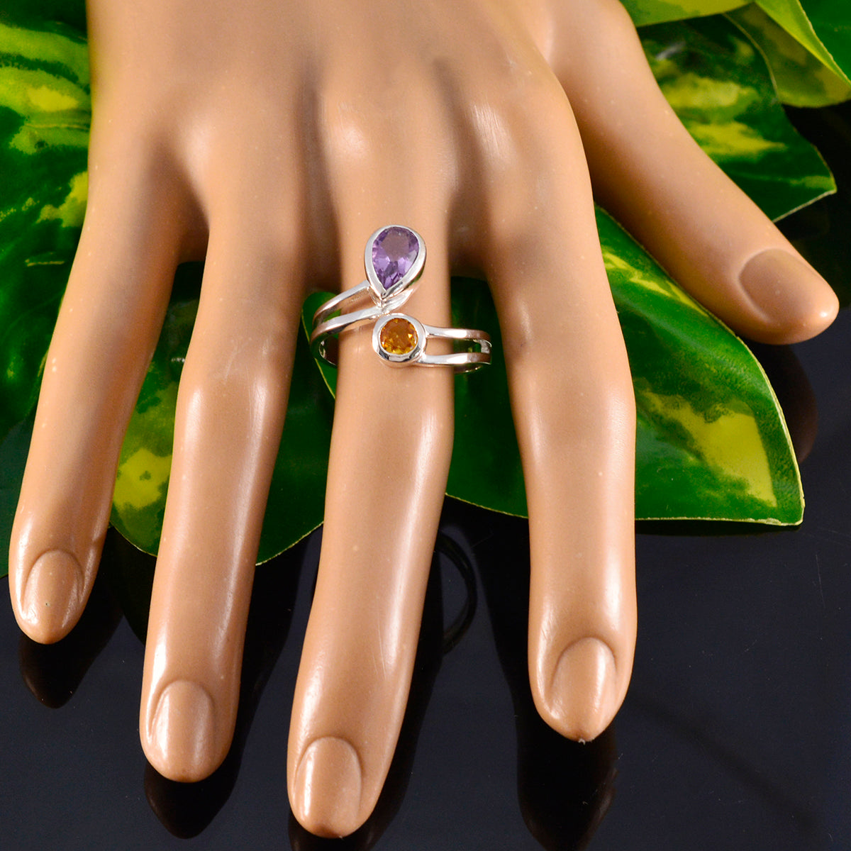 Ines multicolor toi et moi ring with purple and orange gemstones on a display hand