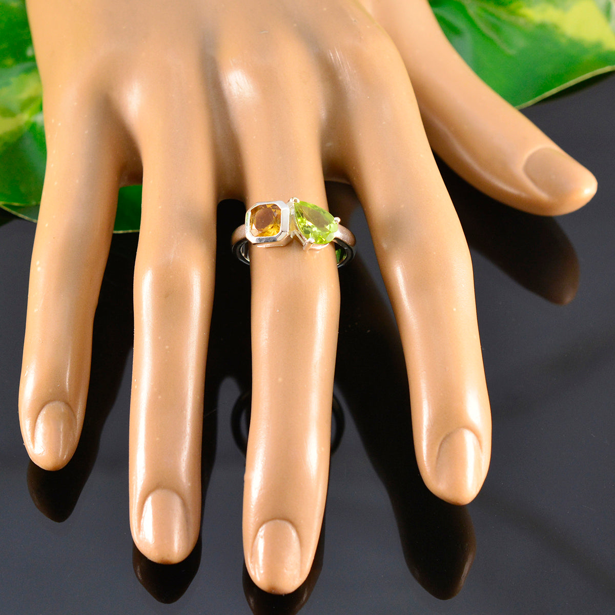 Olivia multicolor Toi et Moi ring on mannequin hand featuring green peridot and amber stones in silver band