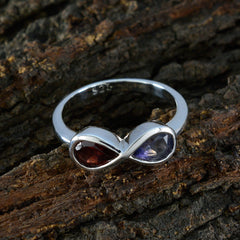 Multicolor toi et moi ring with two gemstones in a stylish infinity design on a rustic background