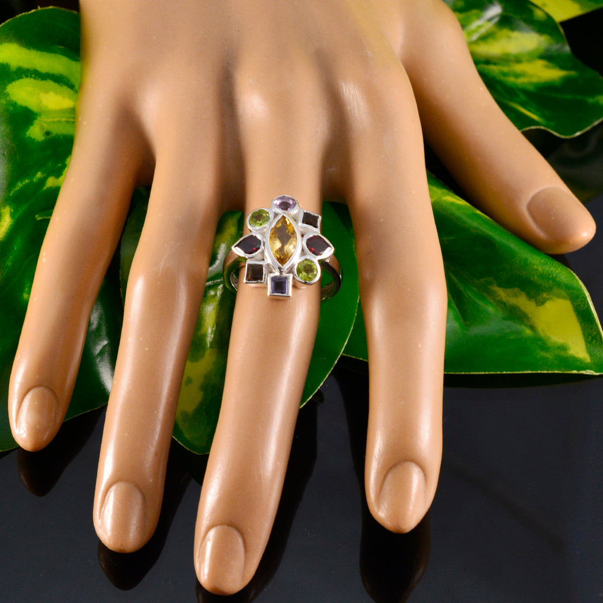 Noelia navratna cocktail ring on display hand showing multicolored gemstone cluster in silver setting