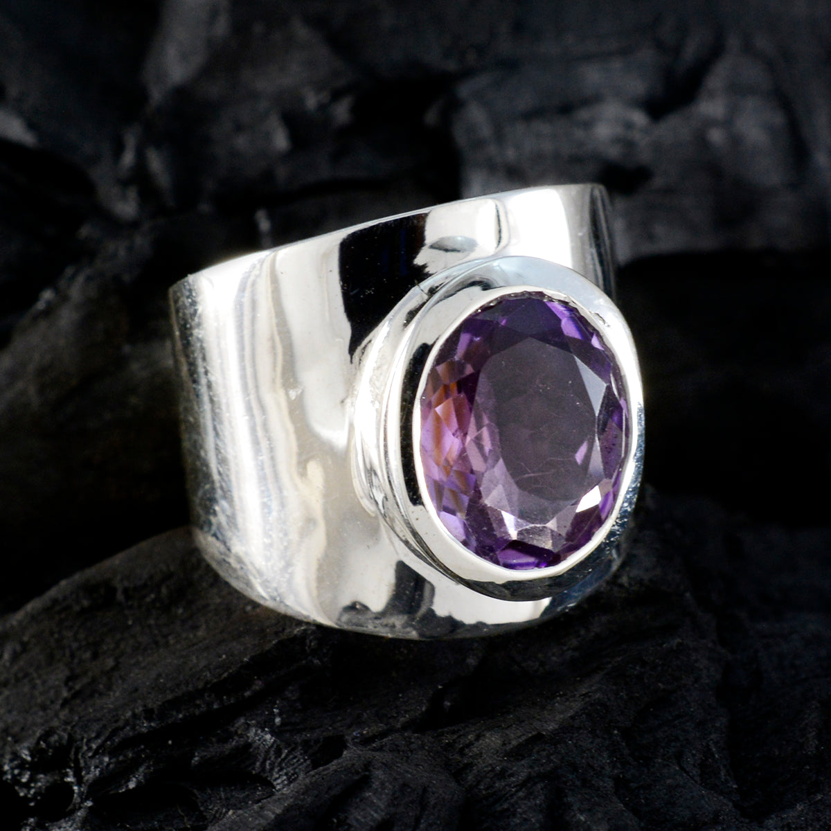 Fernanda purple gemstone solitaire ring with wide silver band on dark textured background