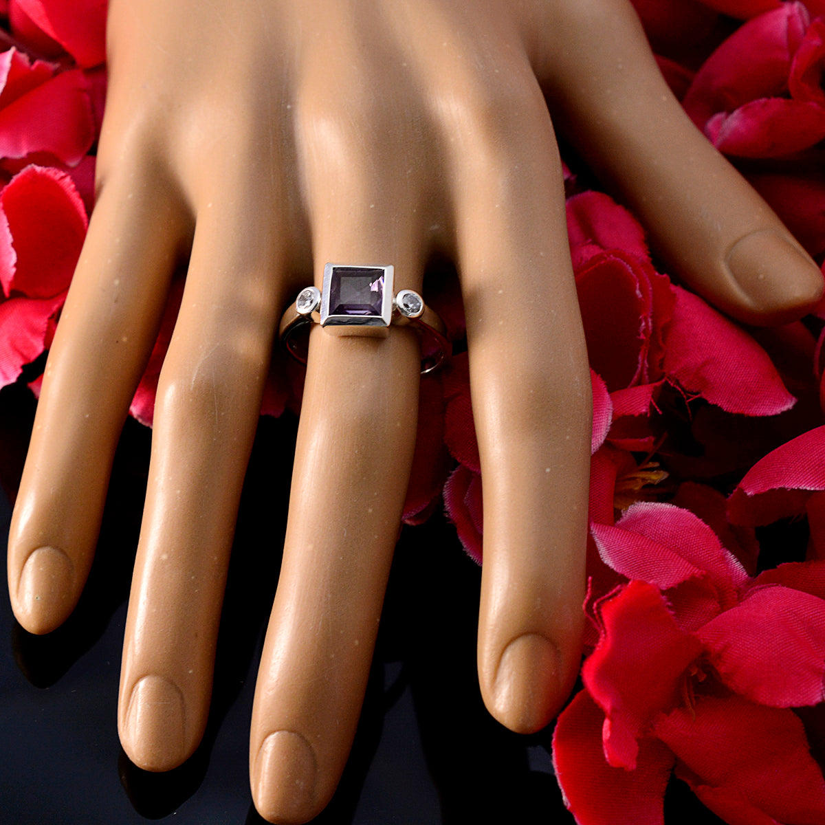 Scarlett purple gemstone trilogy ring with square center stone on finger surrounded by red petals