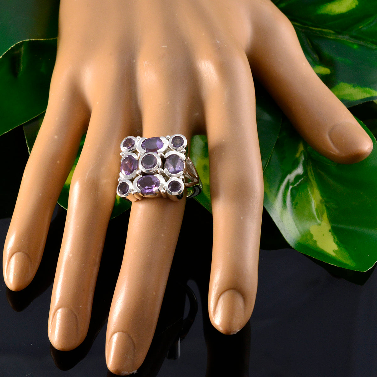 Nia purple navratna ring with multiple purple gemstones on silver band worn on hand