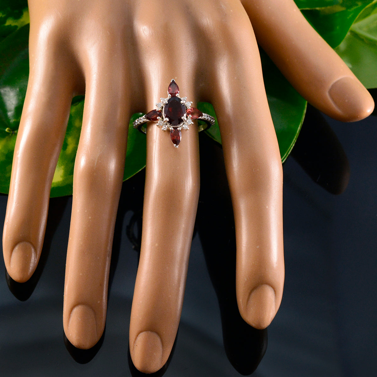 Carolina red gemstone fashion ring with marquise and oval stones and halo on mannequin hand