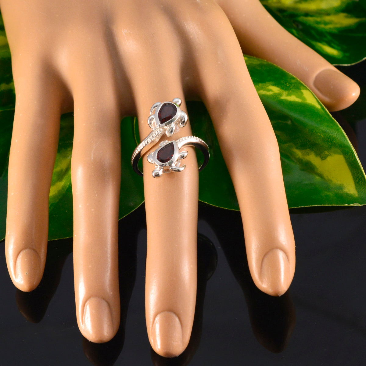 Carolina red gemstone fashion ring with two pear-shaped red stones on silver band displayed on hand