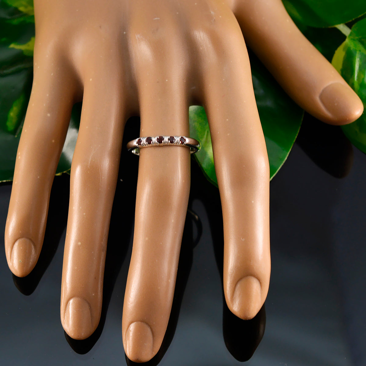 Yuki red gemstone silver ring with multiple red stones on a silver band worn on a mannequin hand