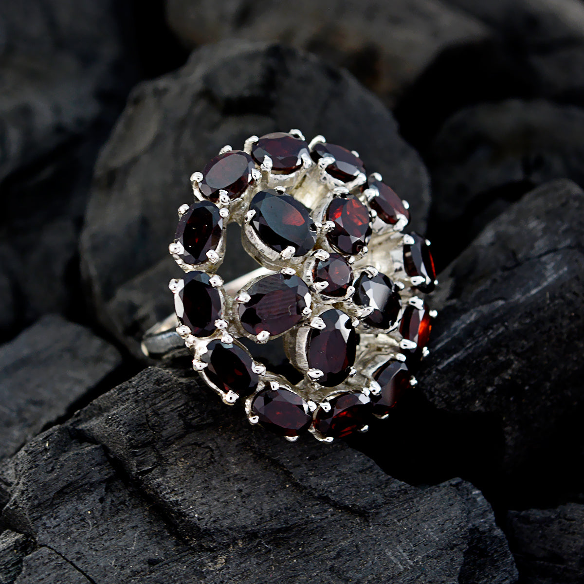 Natalie Victorian red gemstone ring with multiple oval red stones set in silver on dark textured background