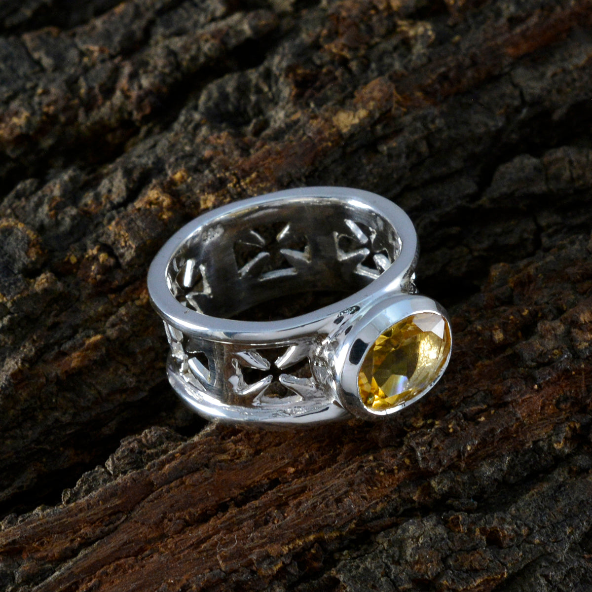 Emily yellow gemstone solitaire ring with silver cross cutout band on textured wood background