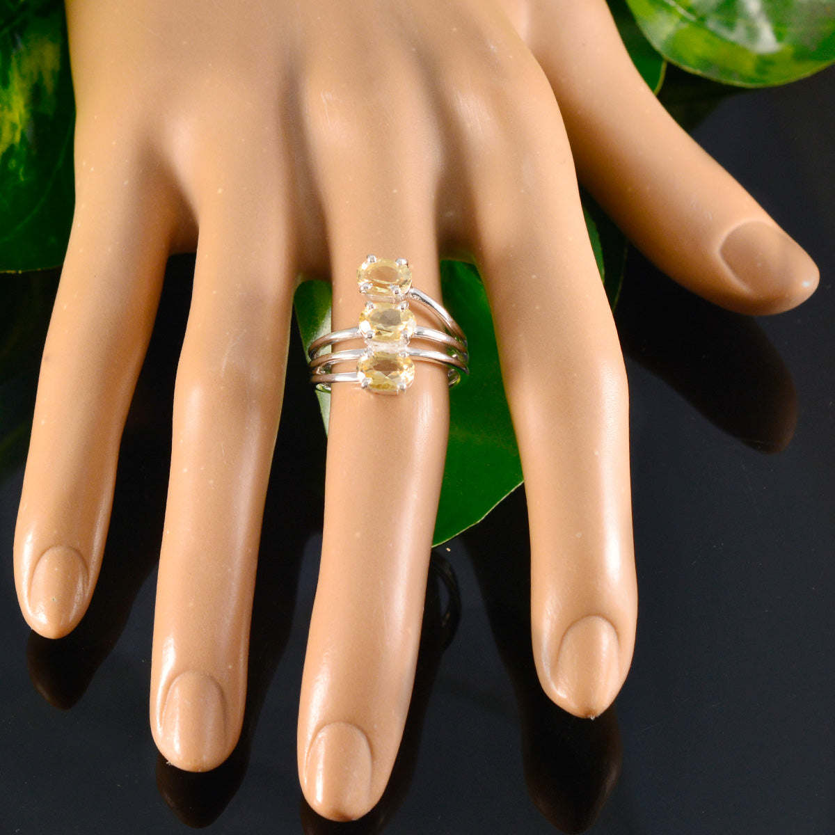 Julia yellow gemstone trilogy ring with three yellow stones set in silver band on mannequin hand