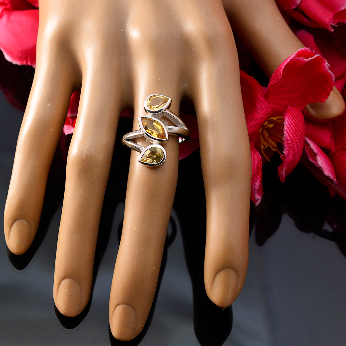 Yellow trilogy gemstone ring with three yellow stones on silver band displayed on mannequin hand