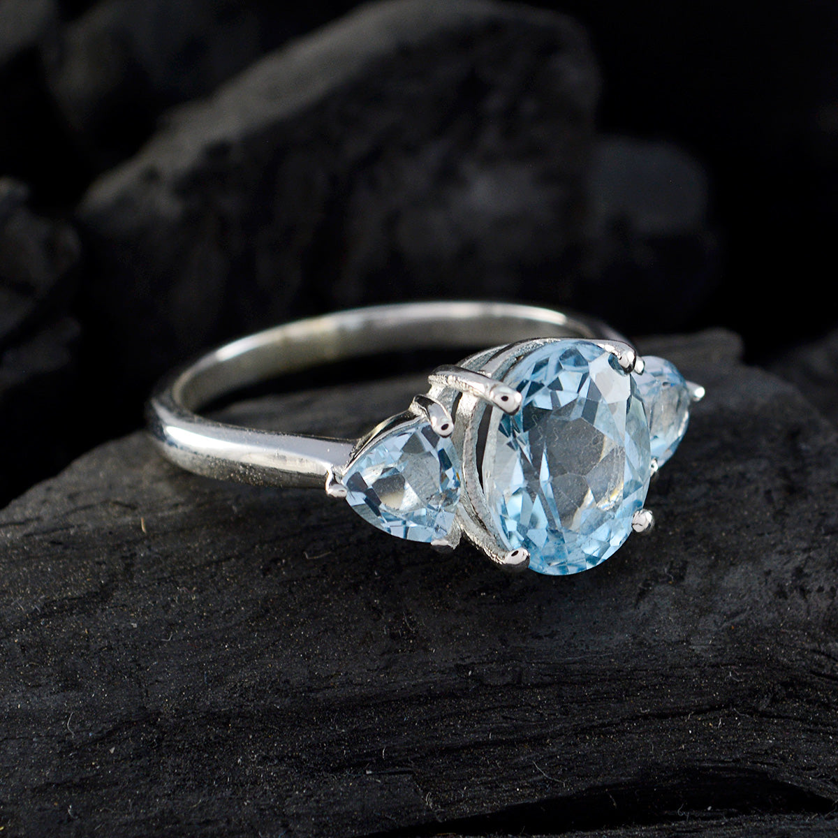 Chloe blue gemstone trilogy ring with three light blue faceted stones on silver band