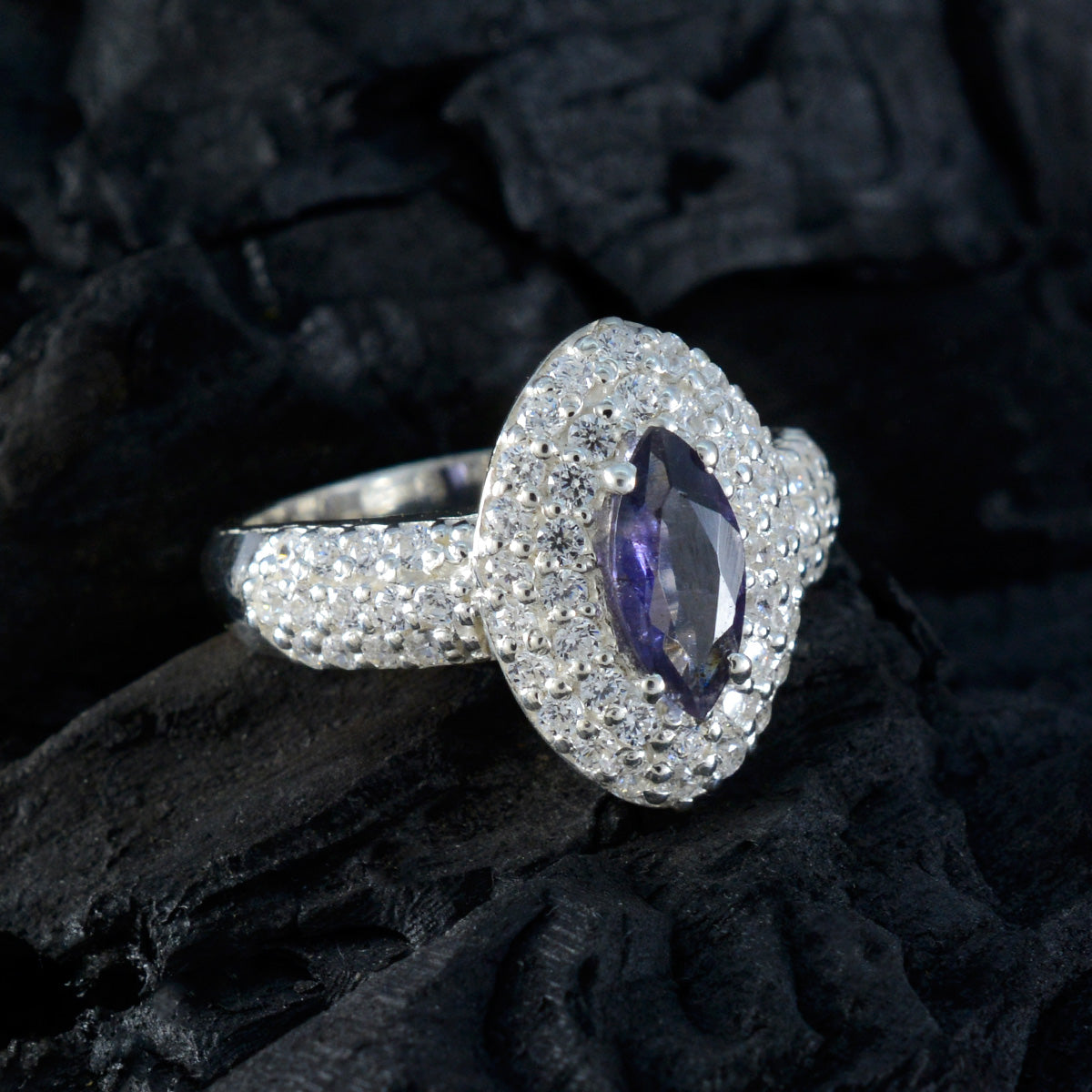 Julieta trendy blue halo ring with marquise center stone and sparkling pave band on dark background