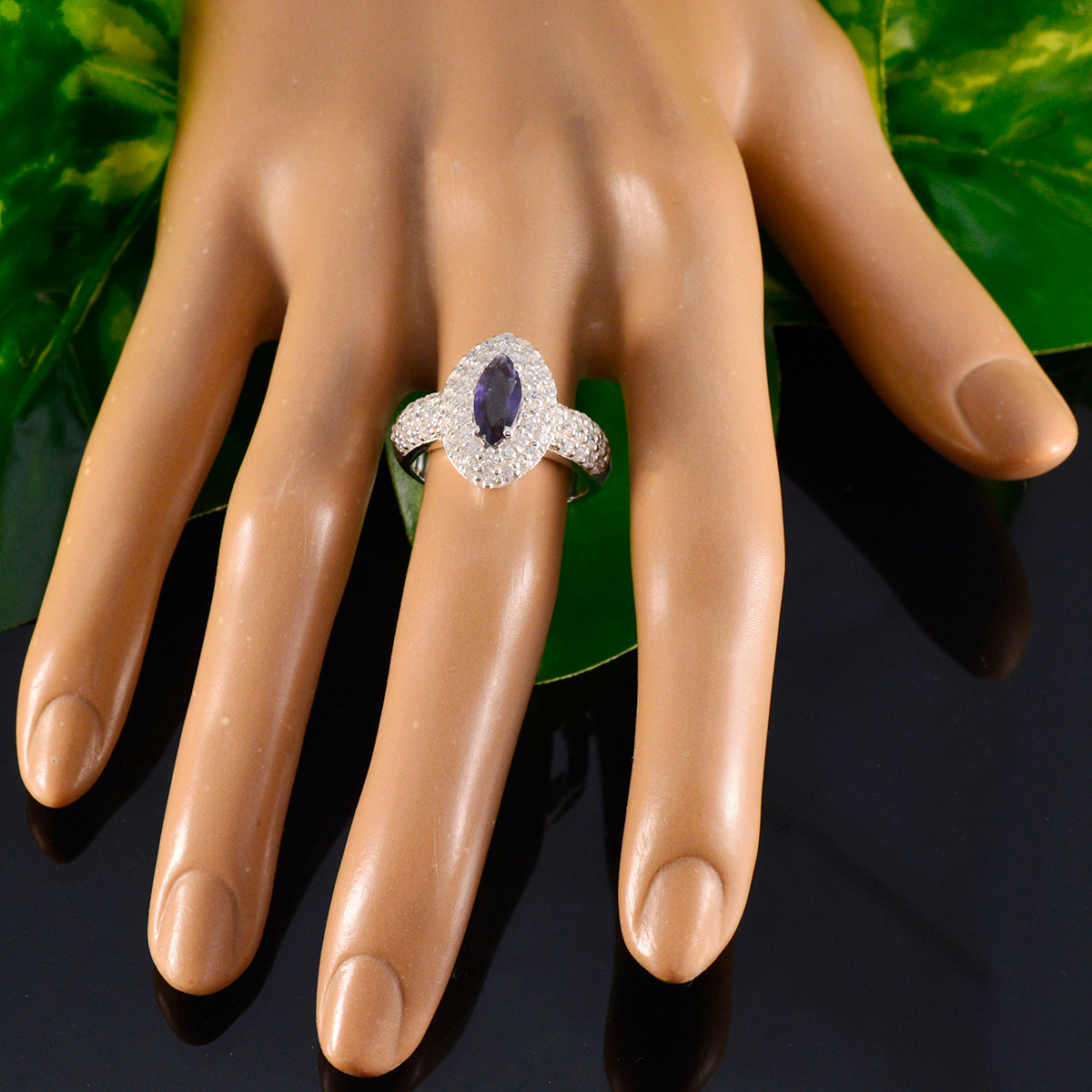Julieta trendy blue halo ring with marquise center stone and sparkling diamond accents on hand