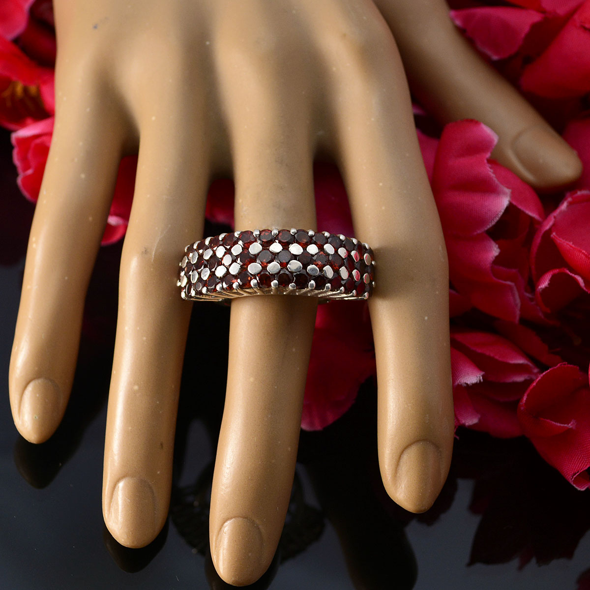 Julia Victorian red gemstone ring with intricate design on display hand surrounded by red petals
